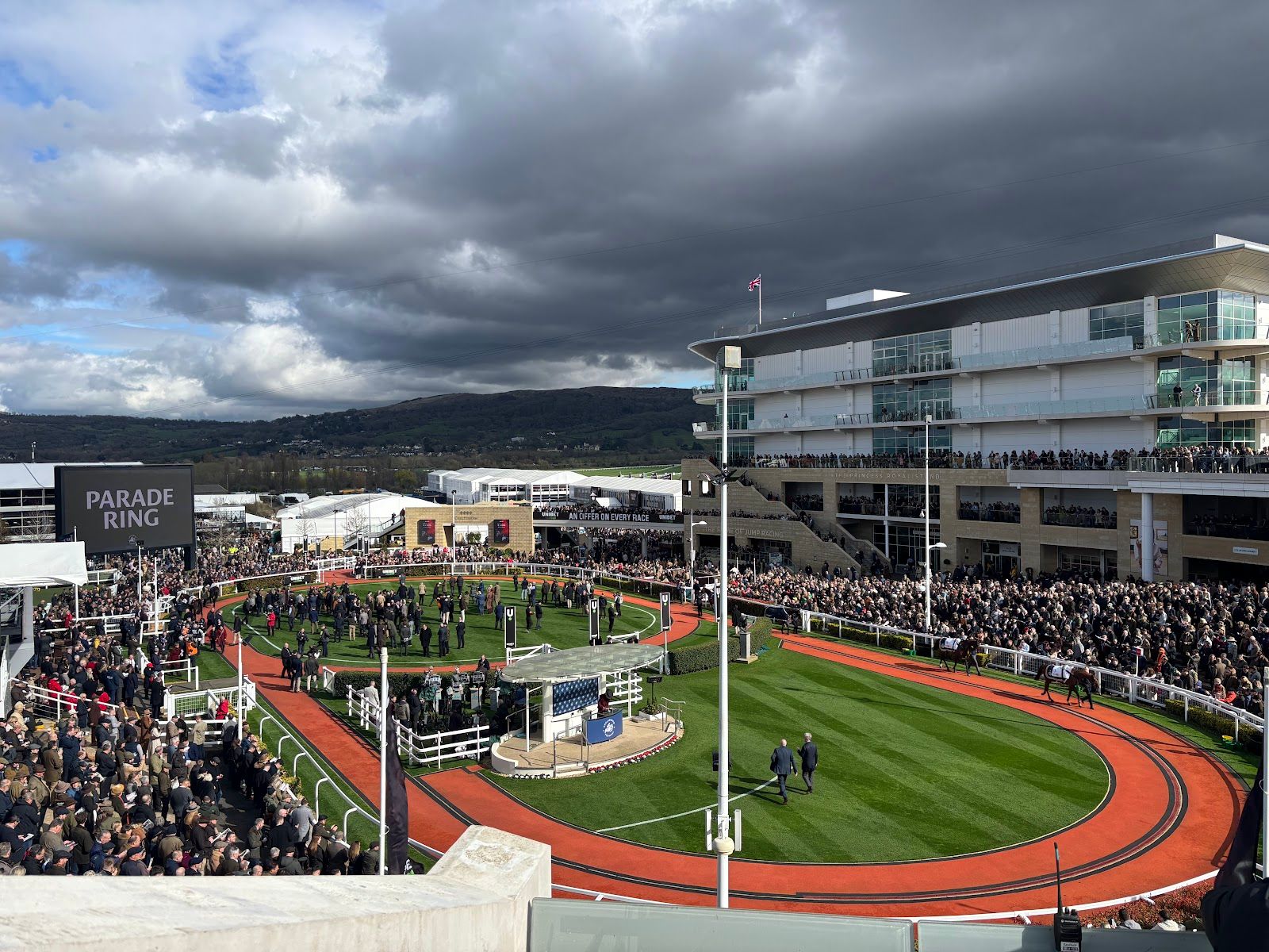Cheltenham Racecourse parade ring with hospitality stands and grandstand behind