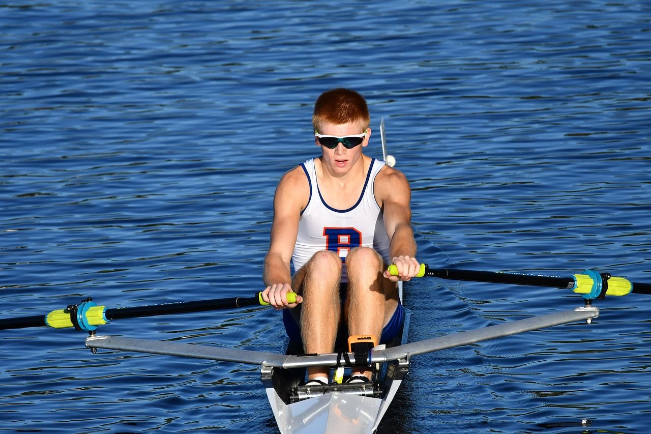 Rowing crew sculling in competitive formation, reflecting Olympic-level competition