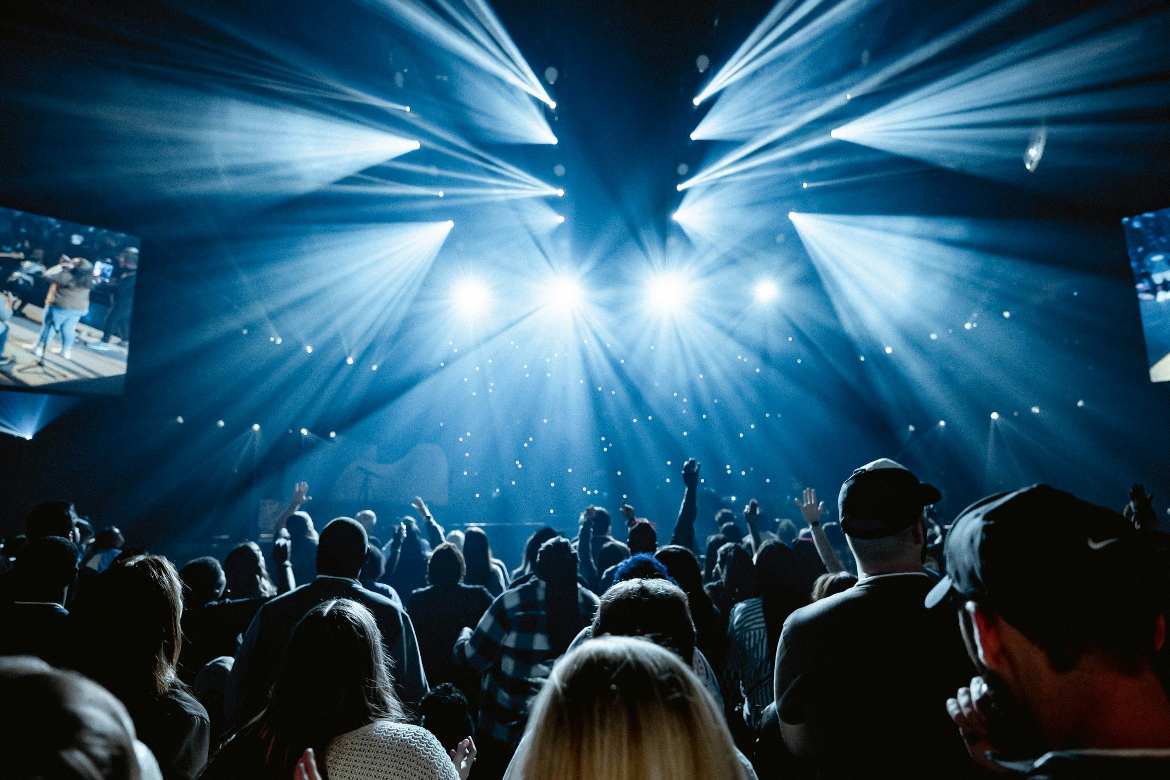 Large crowd in a dark arena during a concert