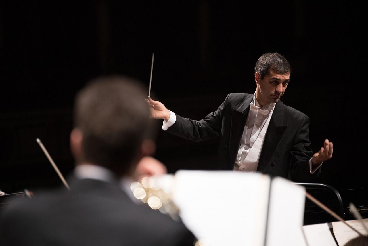 A conductor leading an orchestra, representing the BBC's stewardship of the Proms