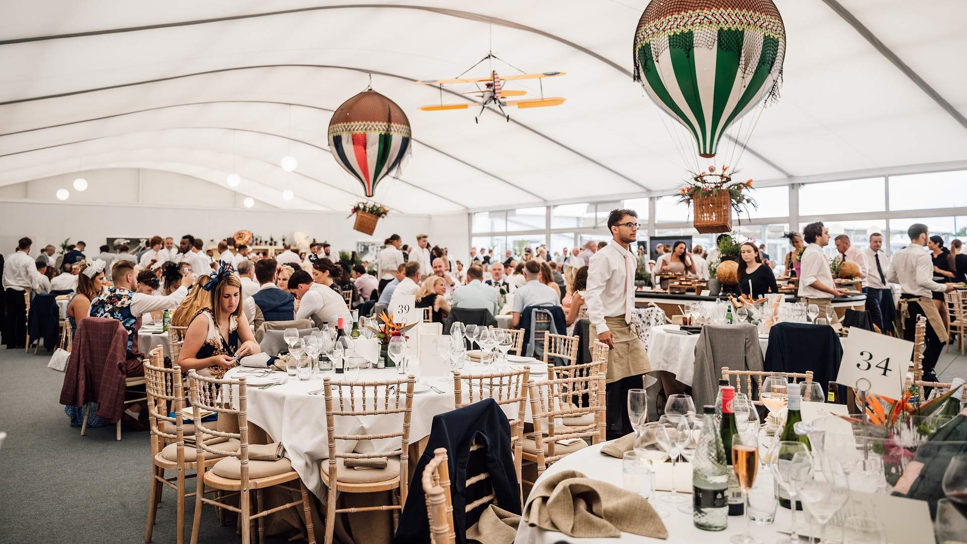 Guests dining inside a marquee at Royal Ascot's Village Enclosure