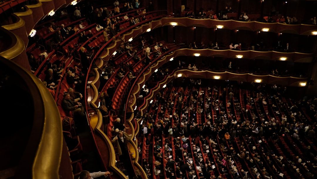 Ornate theatre interior with audience seated in tiered balconies, evoking the grandeur of early 20th-century variety performances