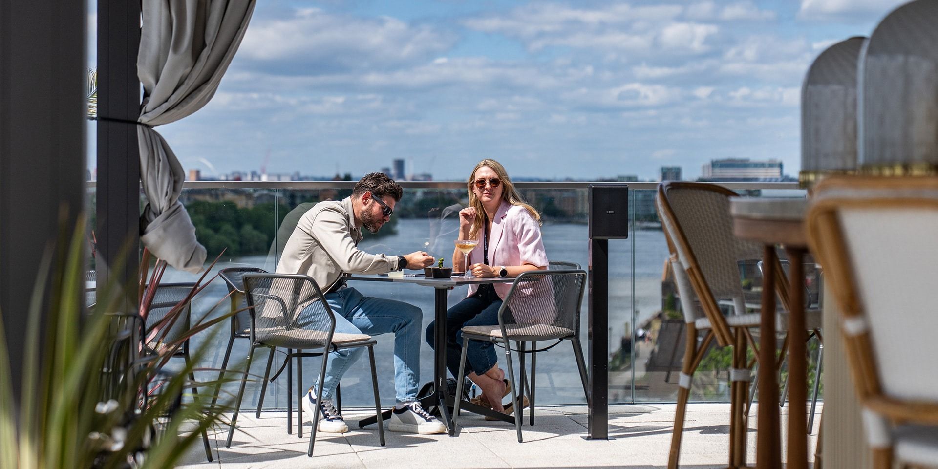 Two guests at a terrace table on The Sky Deck overlooking the River Thames
