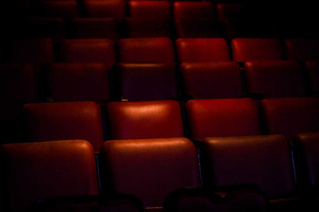 Empty red theatre seats, evoking the pandemic closure of London theatres