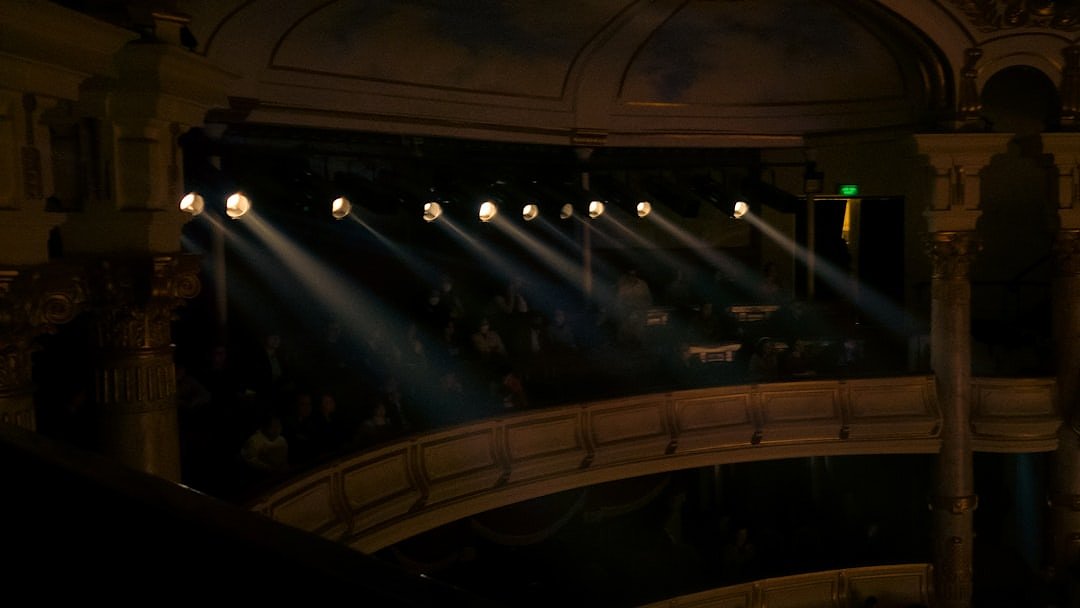Performers standing on a grand illuminated stage during a gala performance