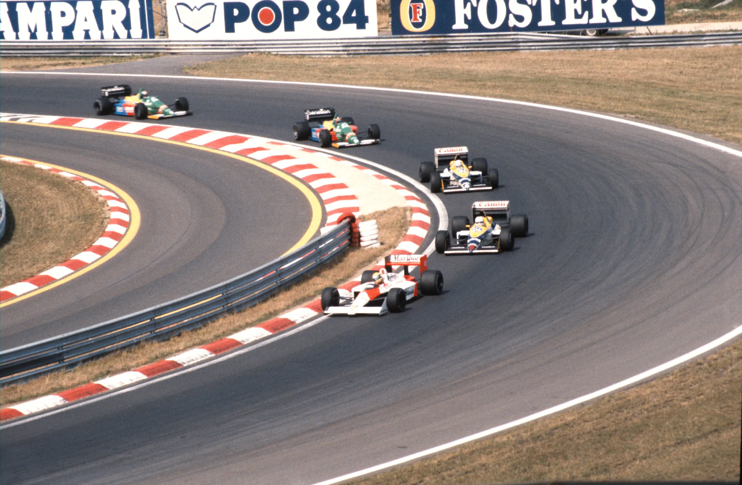 Formula 1 cars racing wheel to wheel on a tight circuit