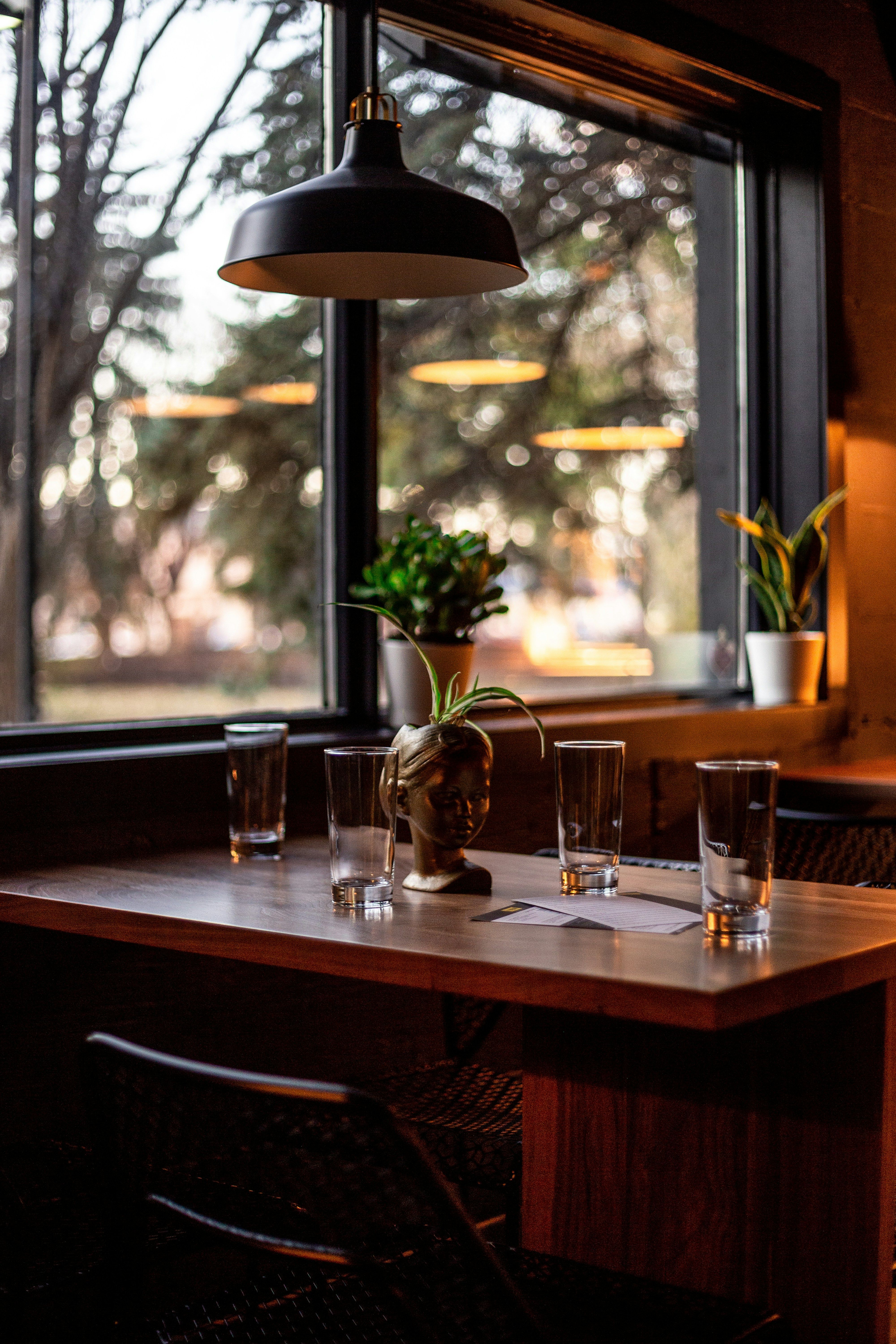 Wine glasses and pendant lamp over a wooden table