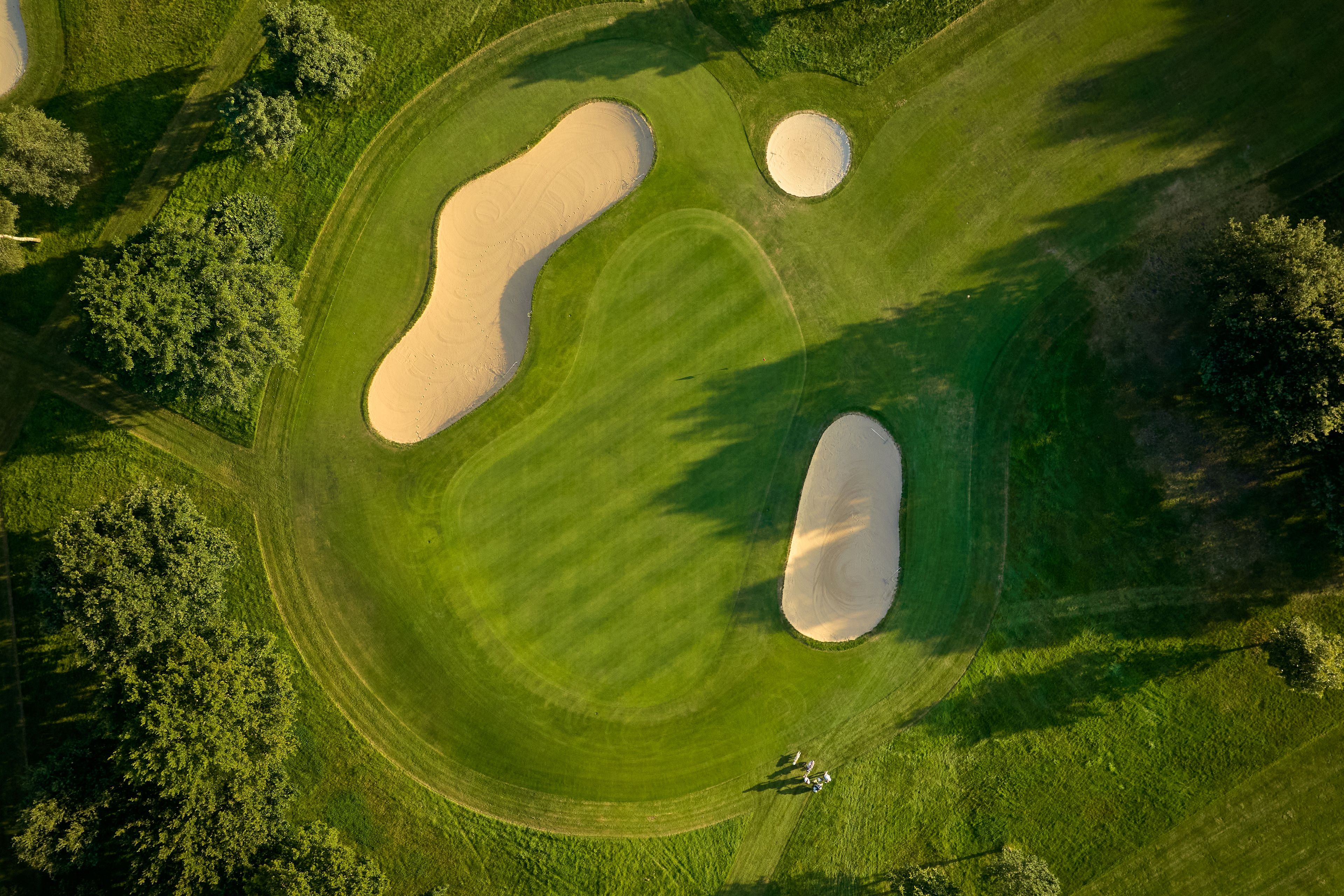 Birds eye view of a well maintained green surrounded by bunkers