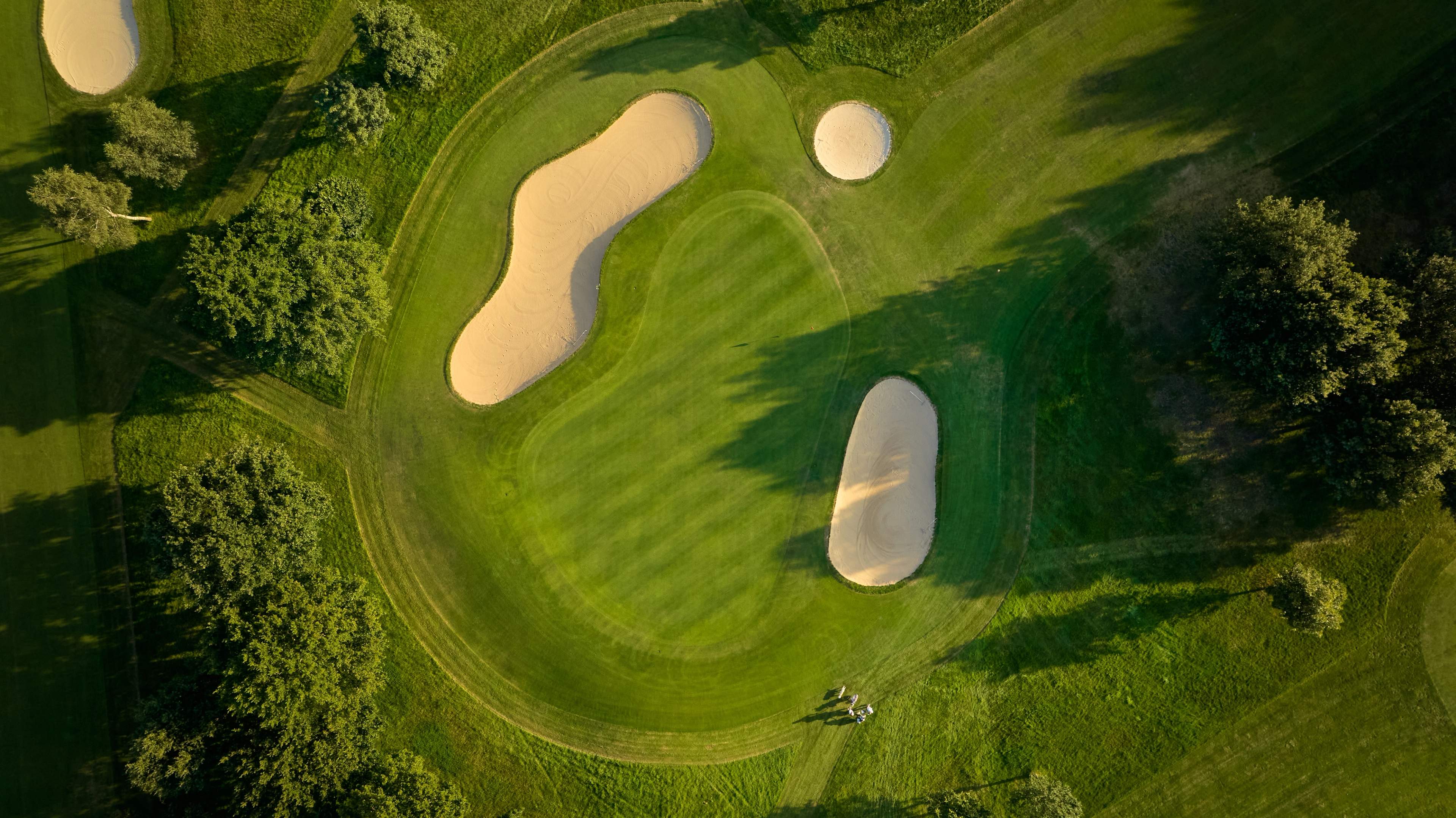 Birds eye view of a well maintained green surrounded by bunkers