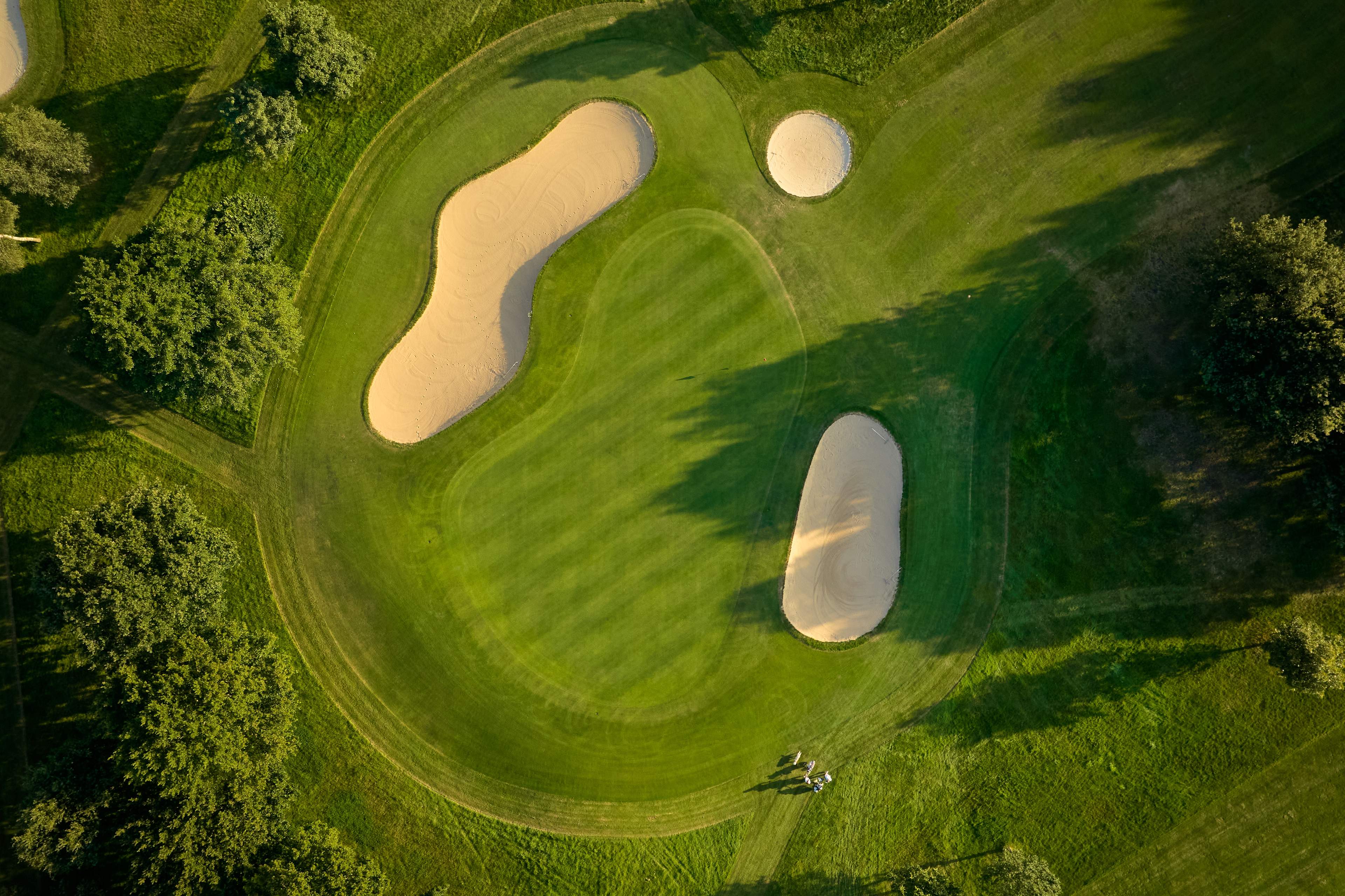Birds eye view of a well maintained green surrounded by bunkers