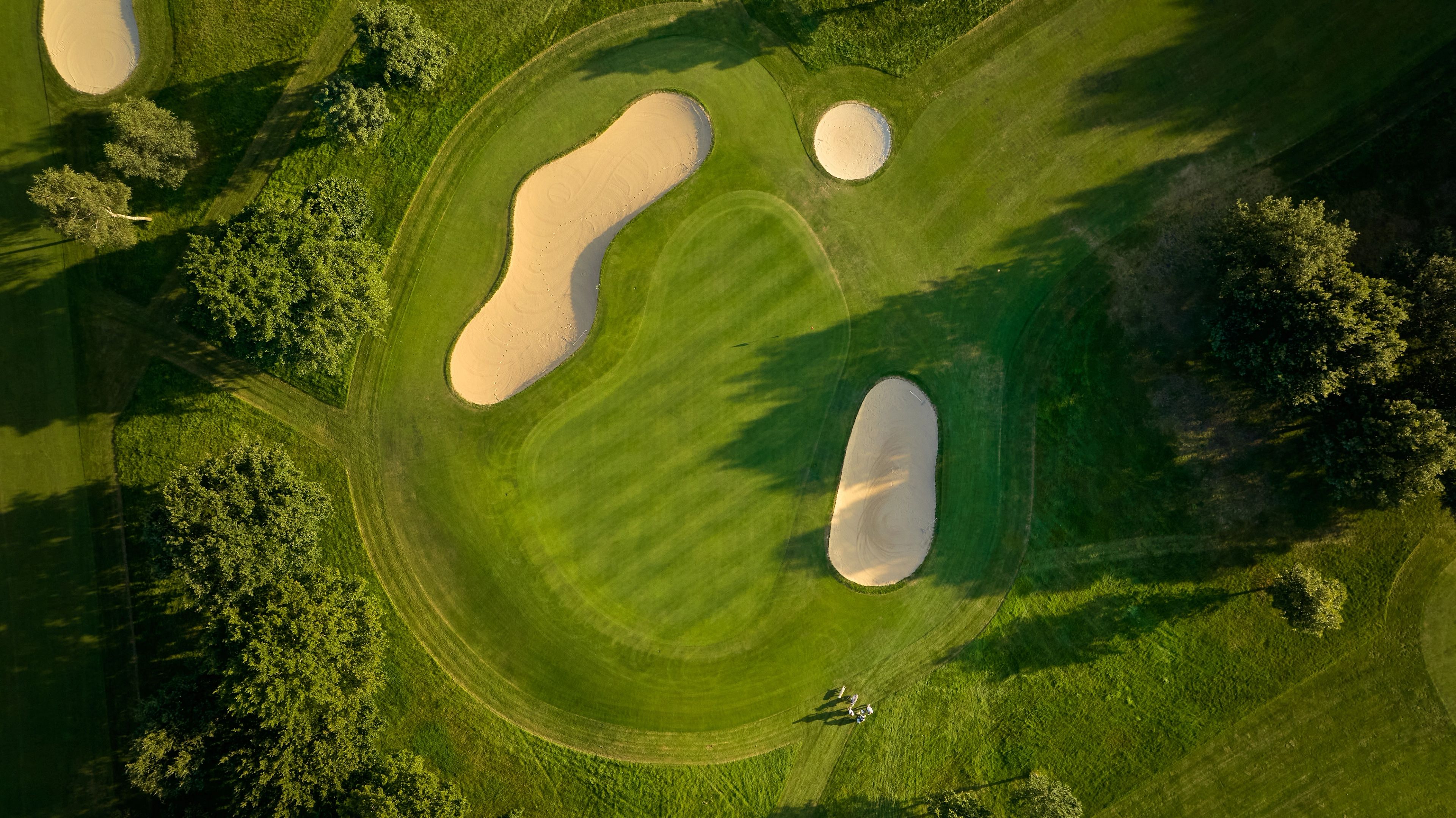 Birds eye view of a well maintained green surrounded by bunkers