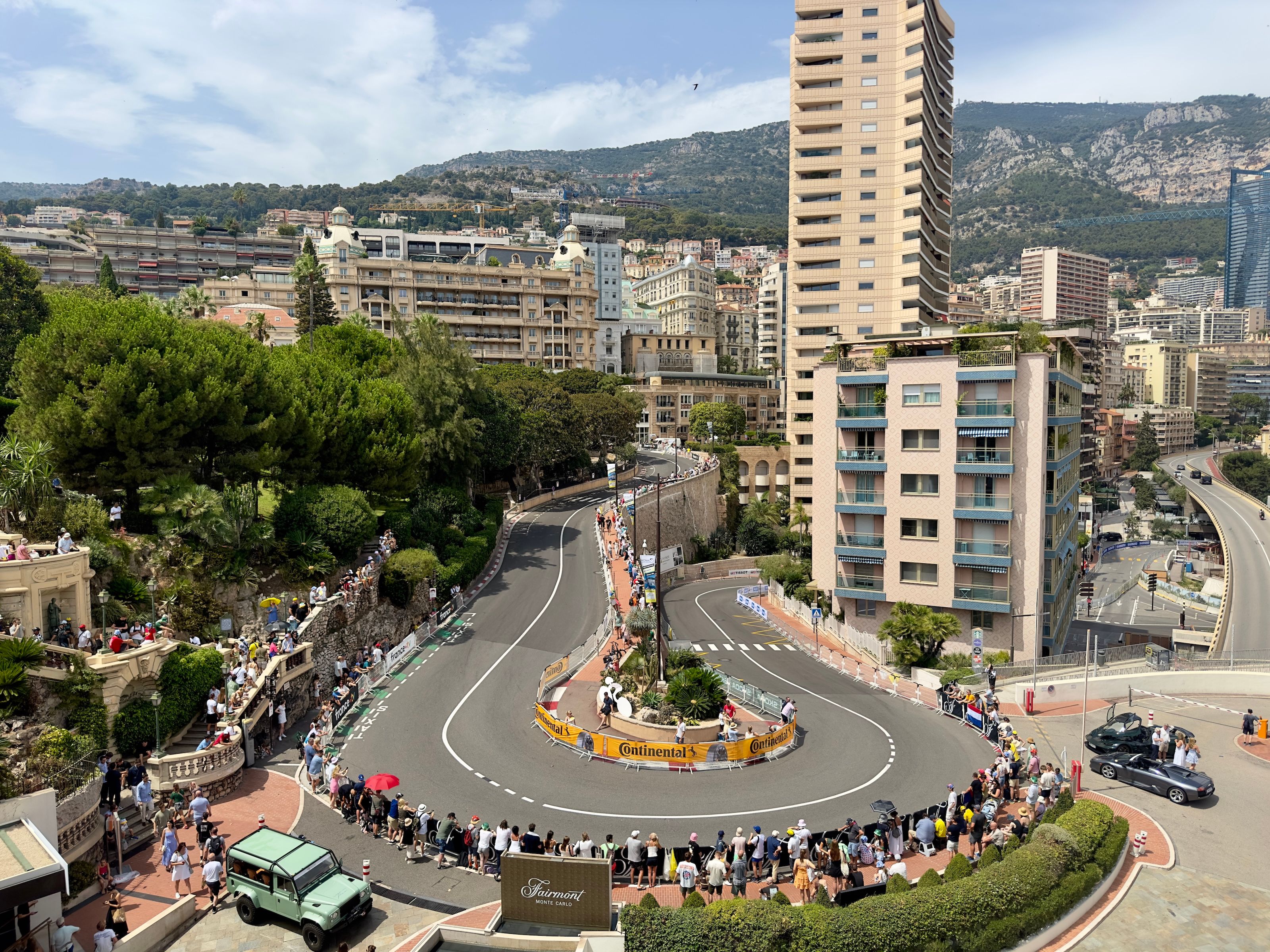 The Fairmont Hairpin seen from above, with spectators lining the barriers and the Fairmont sign beside the track