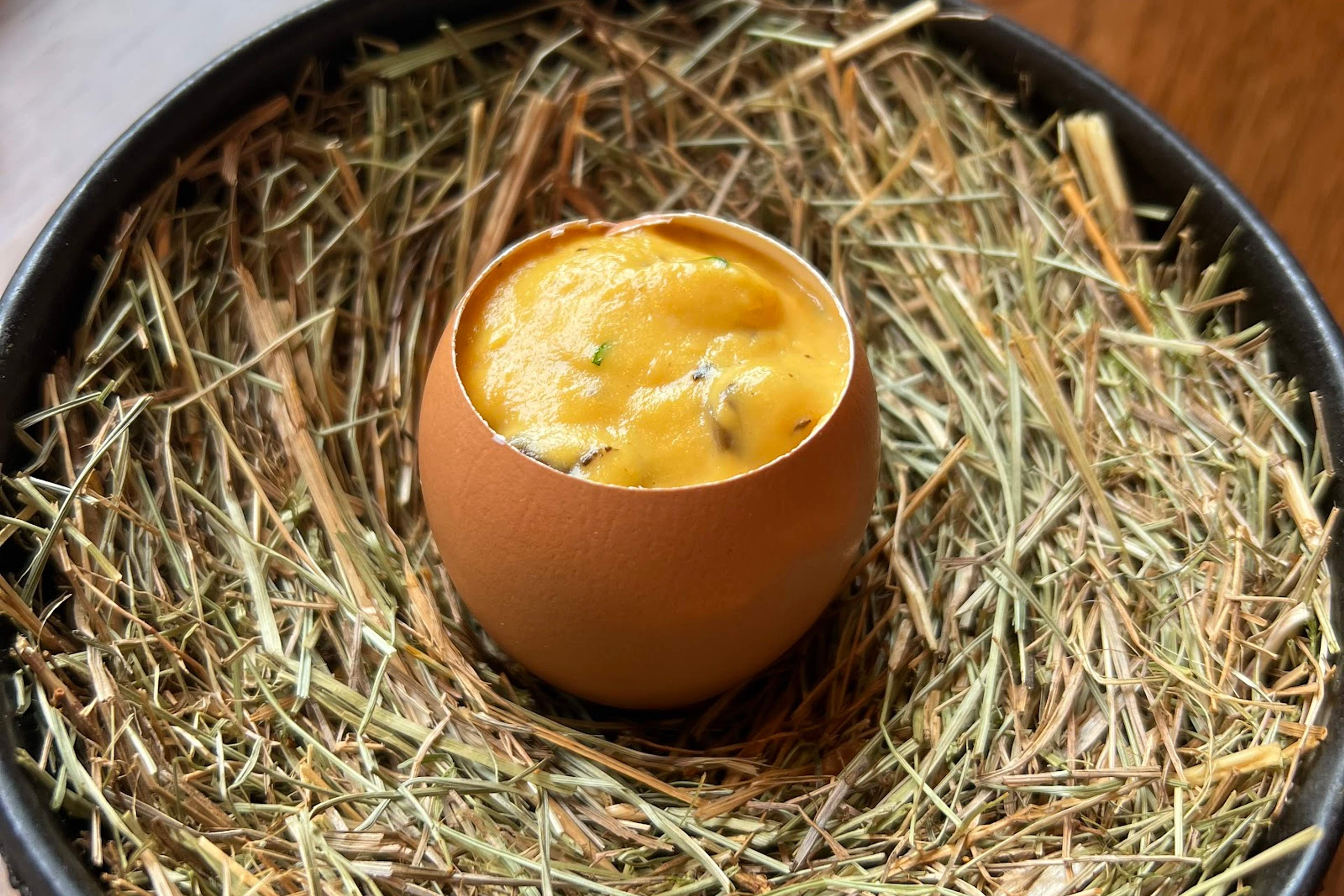 A dish served in an eggshell on a nest of hay at HIDE