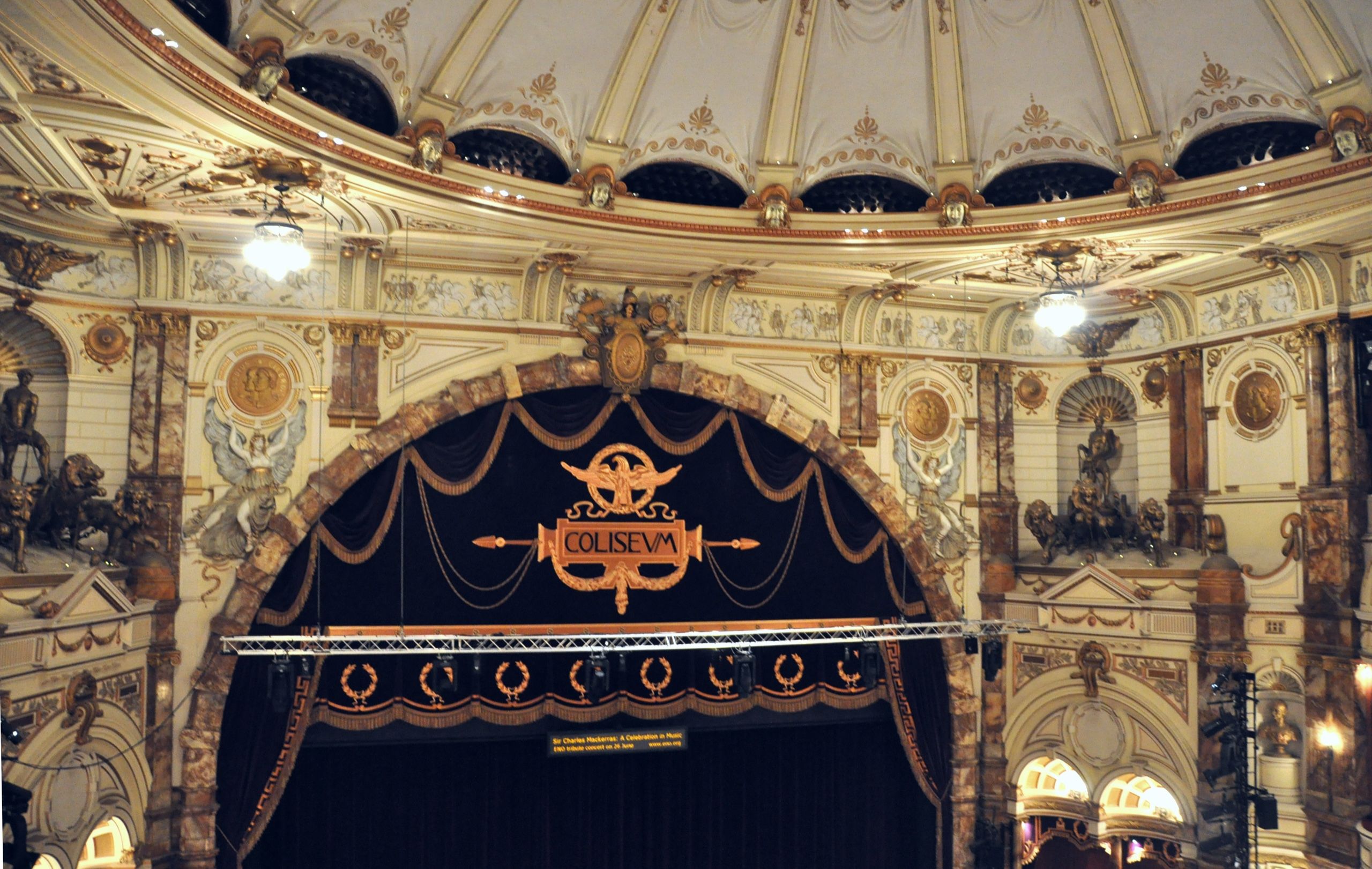 The London Coliseum auditorium from the dress circle: house curtain, boxes and gilded plasterwork