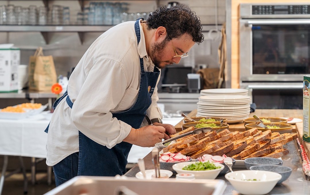 A chef plating a dish in a fine dining kitchen