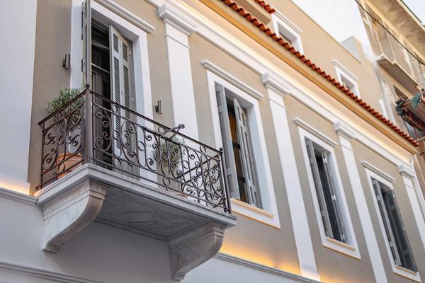Restored neoclassical facade of Emerald Hotel Athens on Perikleous Street — arched doorways and ornate plasterwork in the historic centre