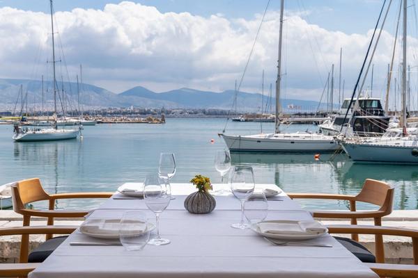 The terrace of Papaioannou seafood restaurant overlooking the marina at Mikrolimano in Piraeus, boats and the sea in the background