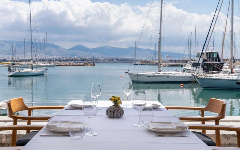 The terrace of Papaioannou seafood restaurant overlooking the marina at Mikrolimano in Piraeus, boats and the sea in the background