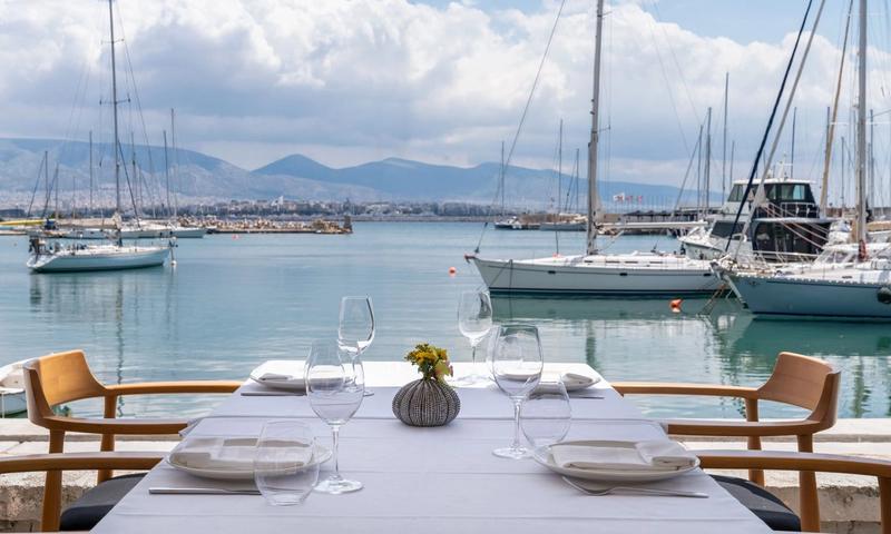 The terrace of Papaioannou seafood restaurant overlooking the marina at Mikrolimano in Piraeus, boats and the sea in the background