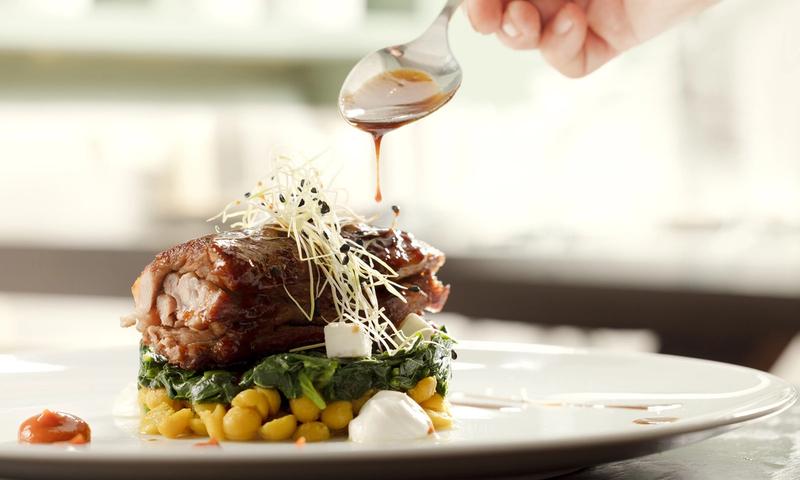 The intimate dining room of Mani Mani restaurant in Athens — warm light, neoclassical details and seasonal dishes from Lakonian Mani on the table