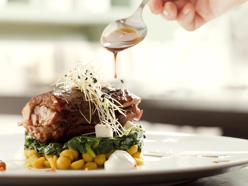 The intimate dining room of Mani Mani restaurant in Athens — warm light, neoclassical details and seasonal dishes from Lakonian Mani on the table