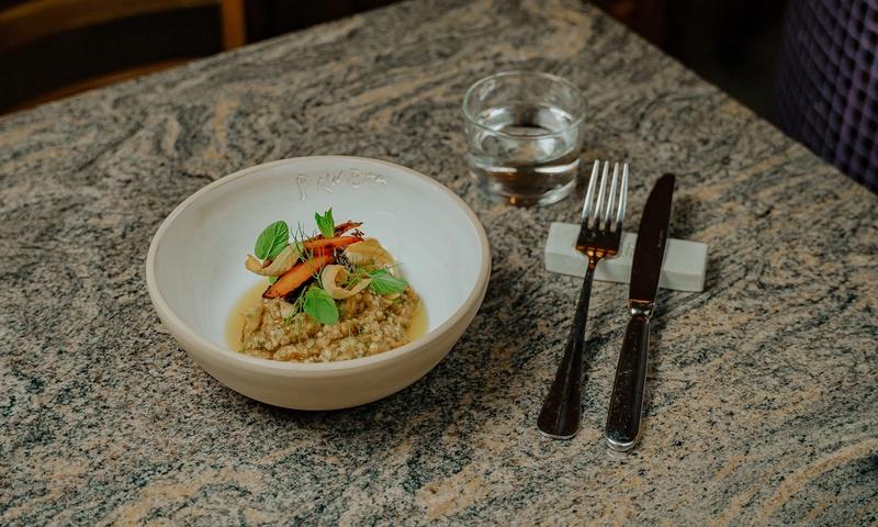 The open kitchen at Raw Bata in Ambelokipi, Athens — a robatayaki charcoal grill showcasing premium Greek ingredients from land and sea