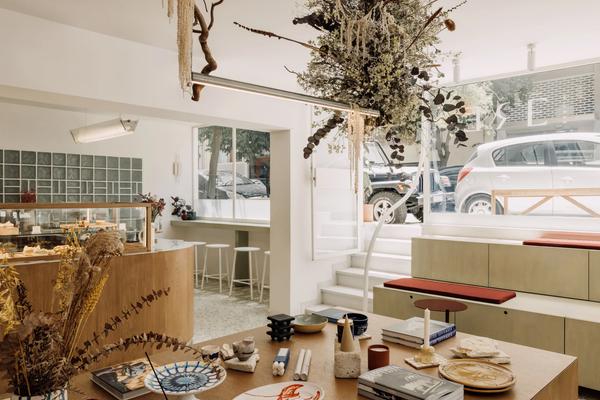 The interior of ERE Athens concept store and café in Koukaki — curated homeware, apothecary products and artisan goods on warm wooden shelves