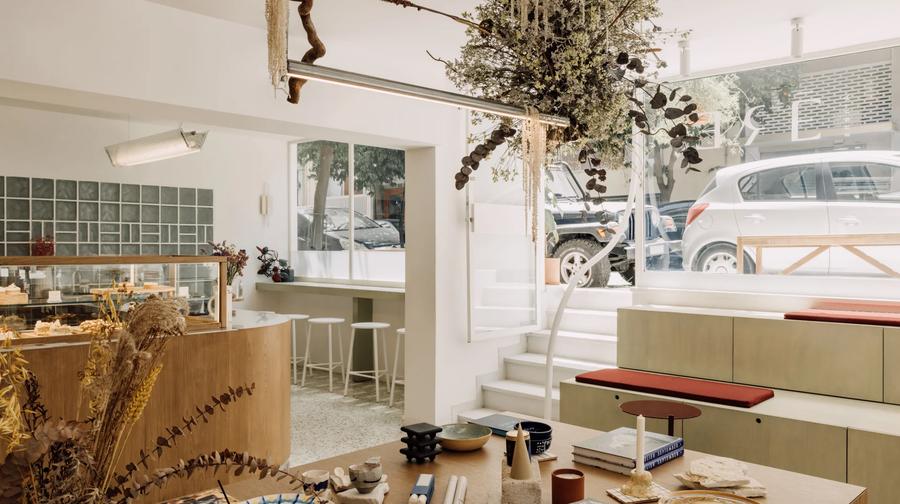 The interior of ERE Athens concept store and café in Koukaki — curated homeware, apothecary products and artisan goods on warm wooden shelves