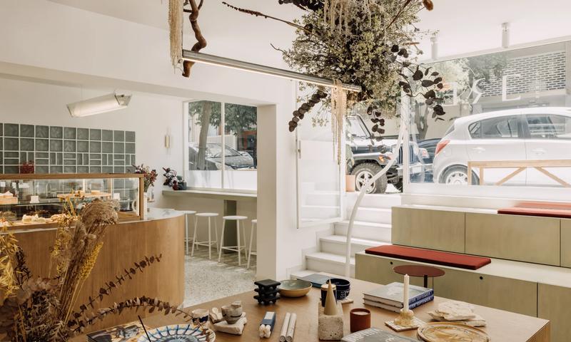The interior of ERE Athens concept store and café in Koukaki — curated homeware, apothecary products and artisan goods on warm wooden shelves