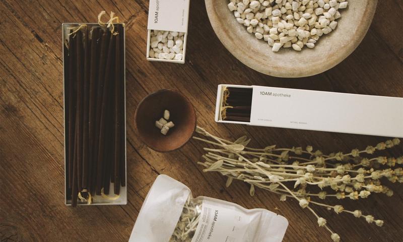 The curated interior of 10AM Apotheke in Kolonaki, Athens — natural beauty and lifestyle products arranged on warm wooden shelves