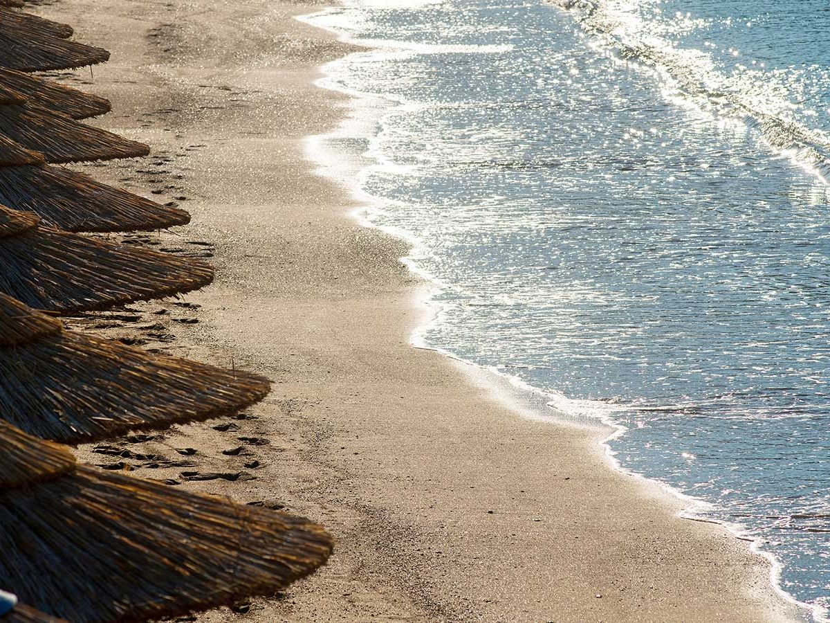 Akti Vouliagmeni Beach on the Athens Riviera — a sheltered bay at the foot of limestone cliffs with calm turquoise water