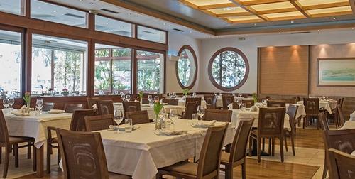 Dourabeis dining room — white tablecloths, wicker chairs