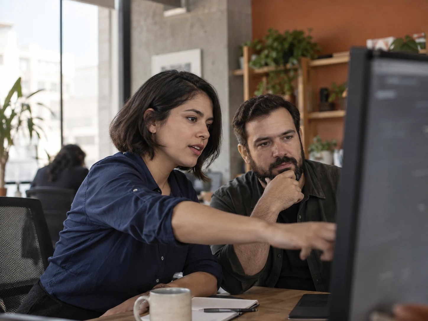 Especialistas revisan un flujo de trabajo en un monitor
