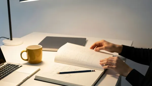 Escritorio con libreta abierta, teclado y una taza de café