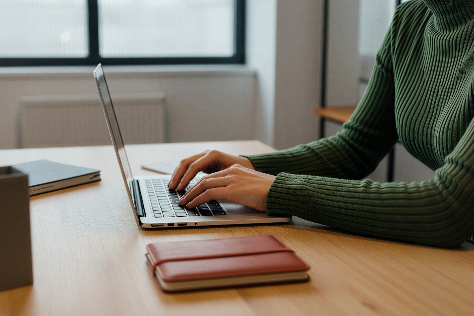 Persona escribiendo en laptop sobre escritorio limpio, ilustrando 'Agente de IA para equipos de ventas: cómo preparar propues