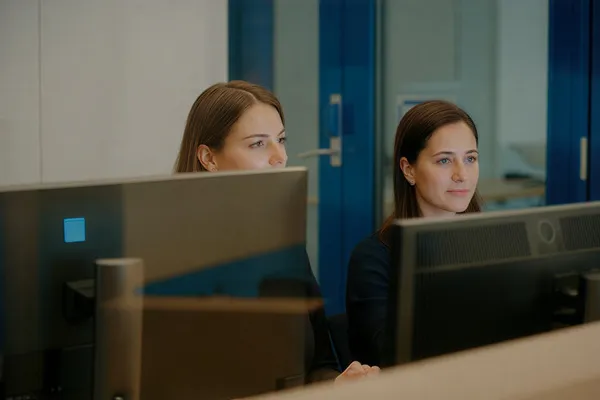 Colaboración en equipo en oficina corporativa, ilustrando 'IA para equipos de ventas: cómo prospectar, calificar y cerrar más