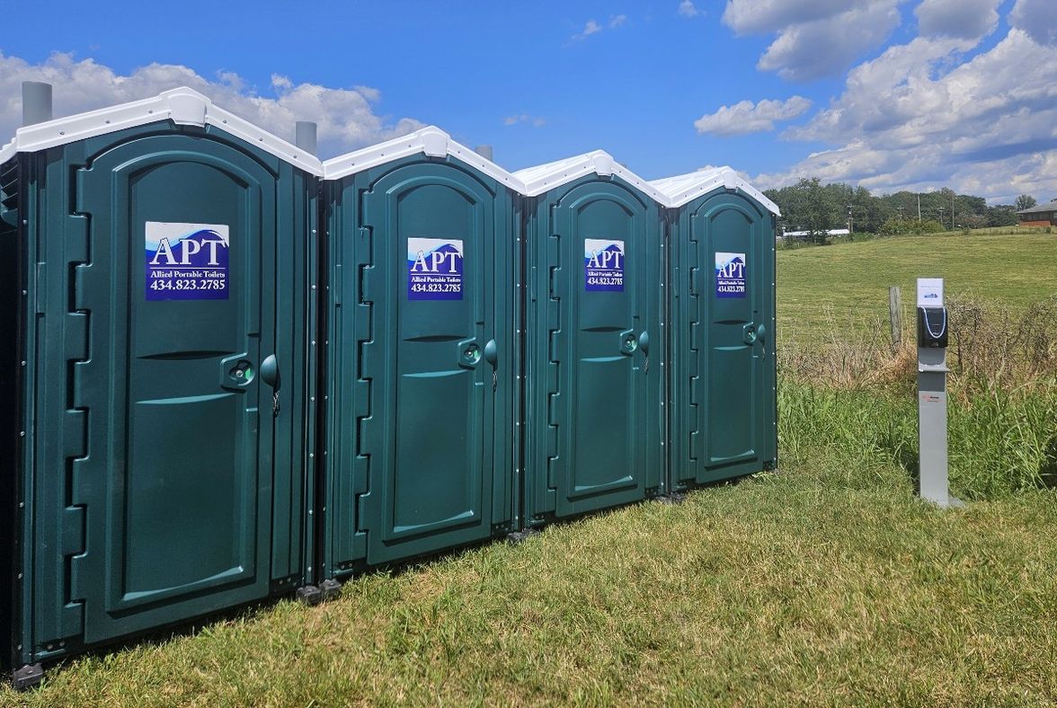 Green portable toilets lined up at an outdoor event location