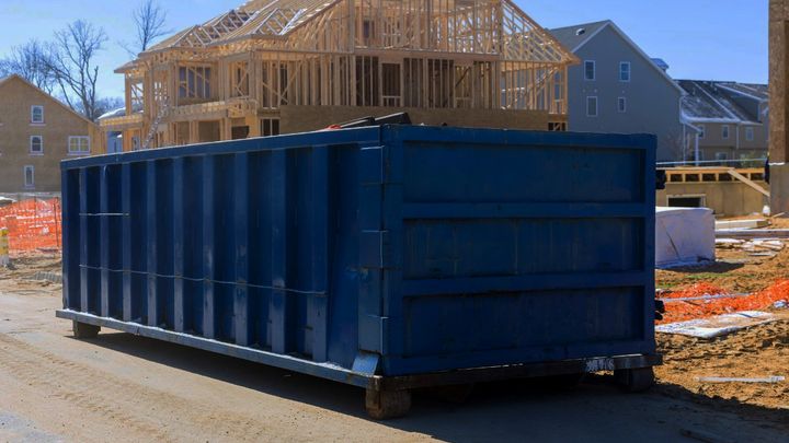 Construction dumpsters staged at a job site for a renovation or cleanout project