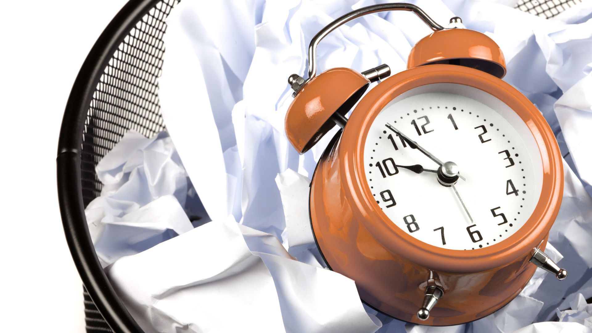 Eine Uhr im Mülleimer mit Papiermüll