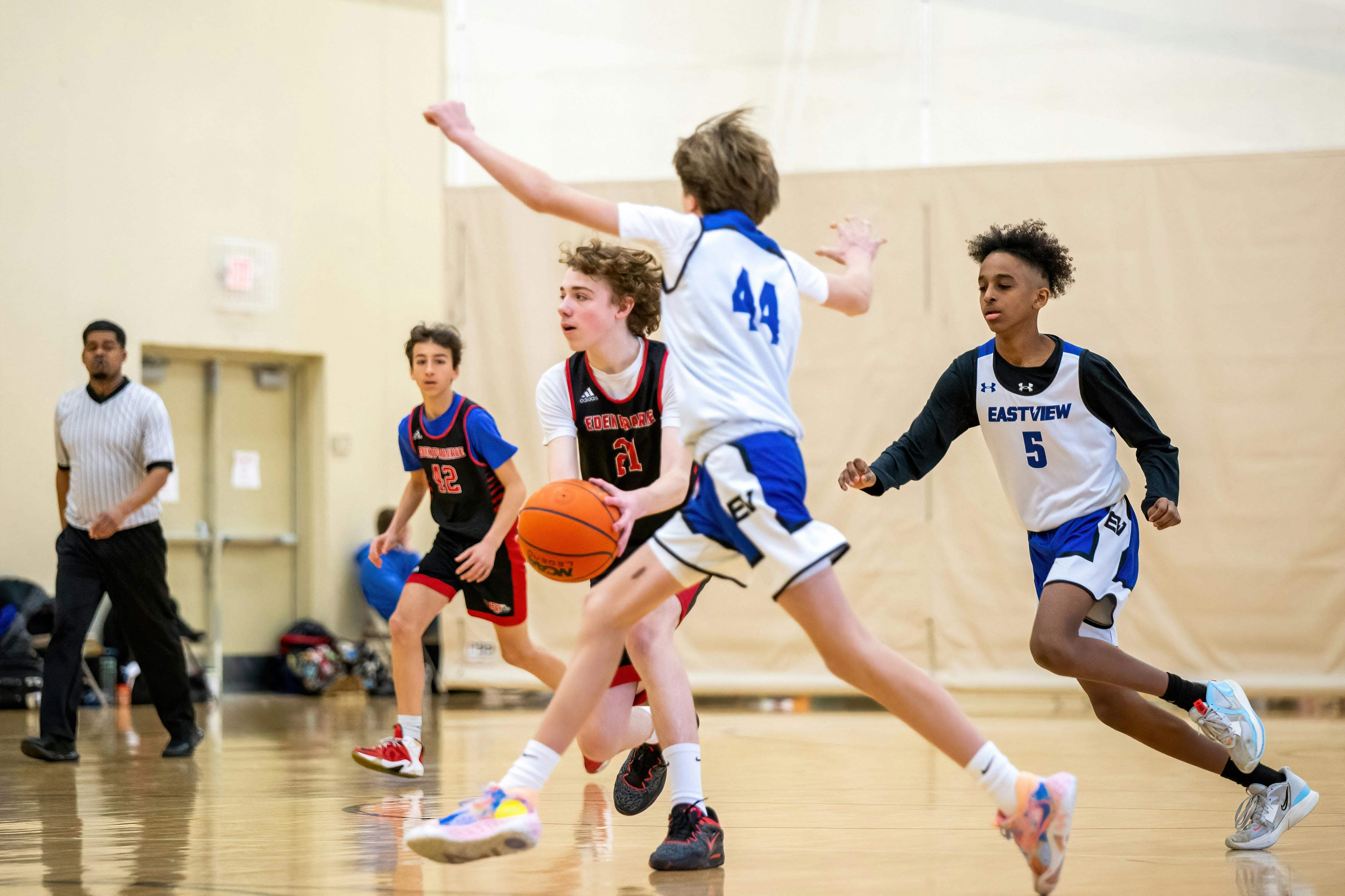 Image Youth basketball players compete on an indoor court, illustrating extracurricular activities after divorce in Illinois