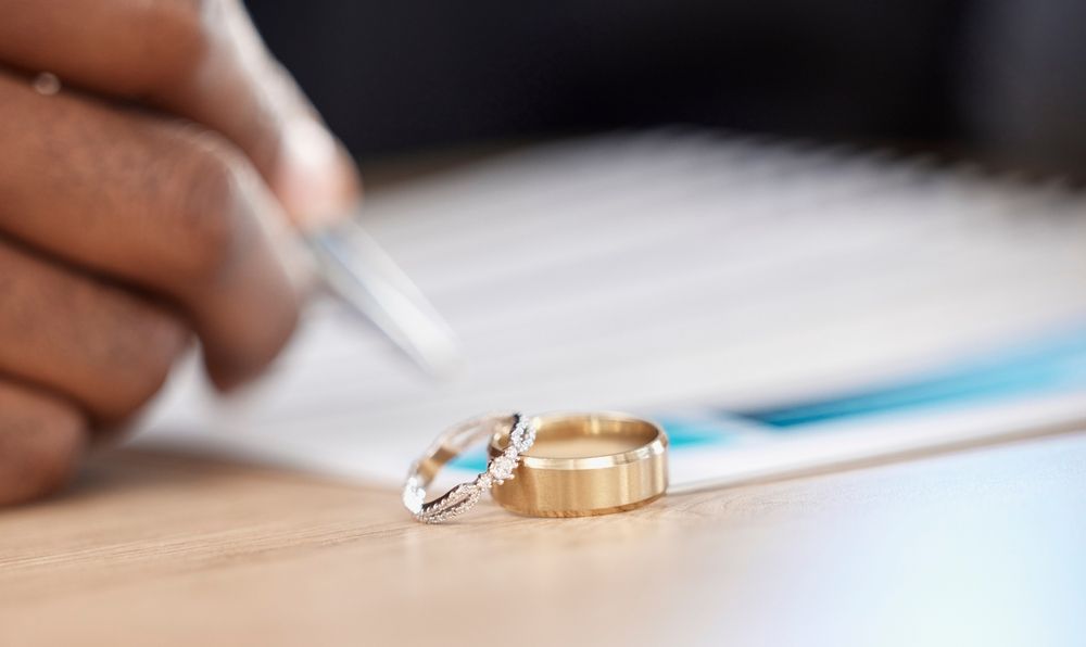 Wedding rings on a legal document being signed representing a high-asset divorce agreement in Illinois involving complex asset division