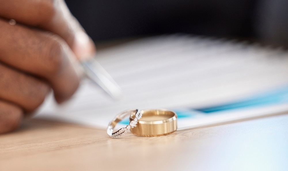 Image Wedding rings on a legal document being signed representing a high-asset divorce agreement in Illinois involving complex asset division