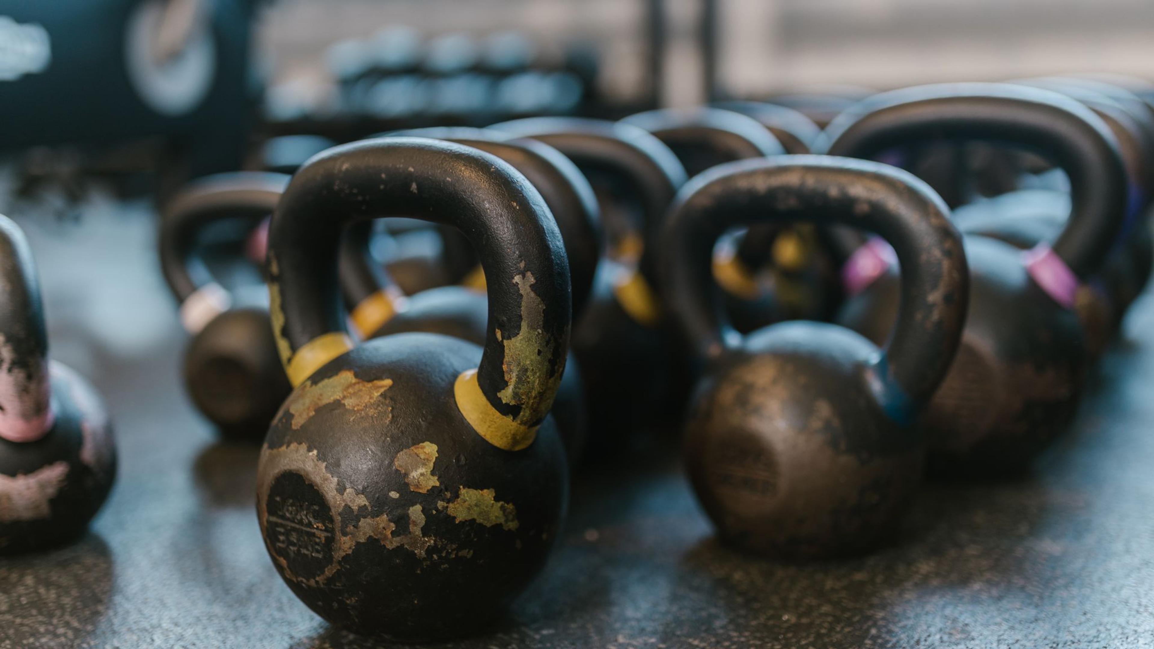 Black kettlebells arranged on a textured gym floor