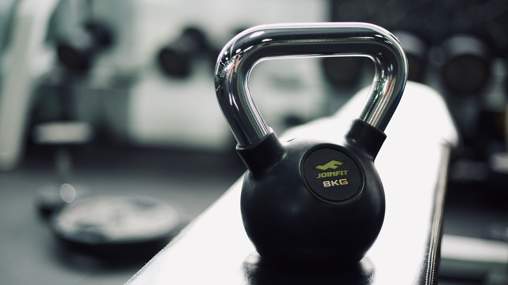 A kettlebell resting on a bench in a dimly lit studio