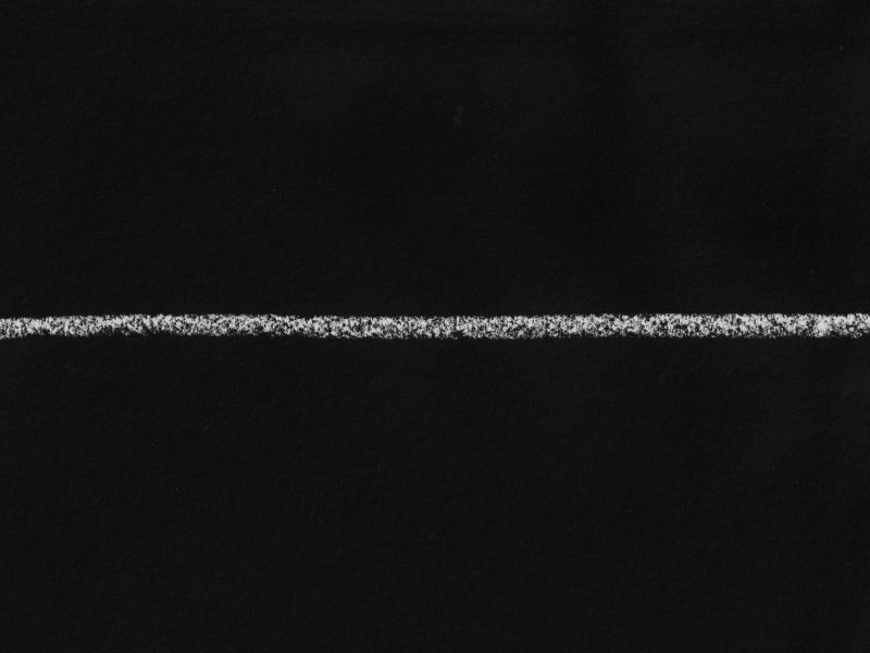 A textured, horizontal white chalk line drawn across the centre of a black paper background.