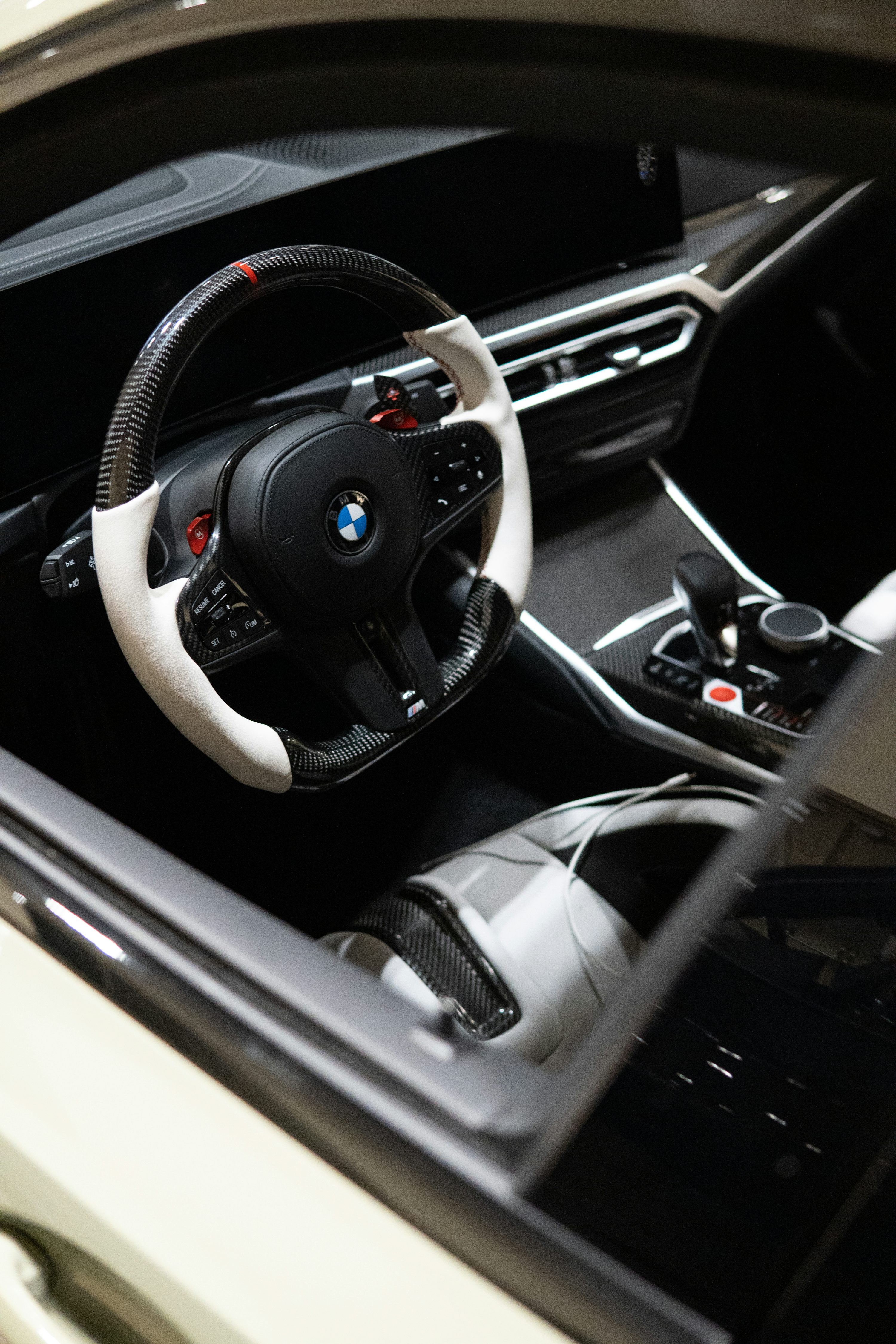 BMW cockpit with a wide dashboard screen, multifunction steering wheel and centre-console controller.