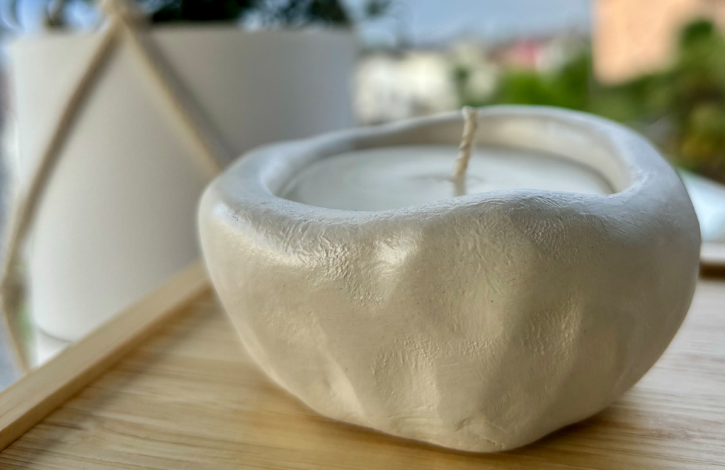 Candela in contenitore realizzato con materiali modellabili a mano