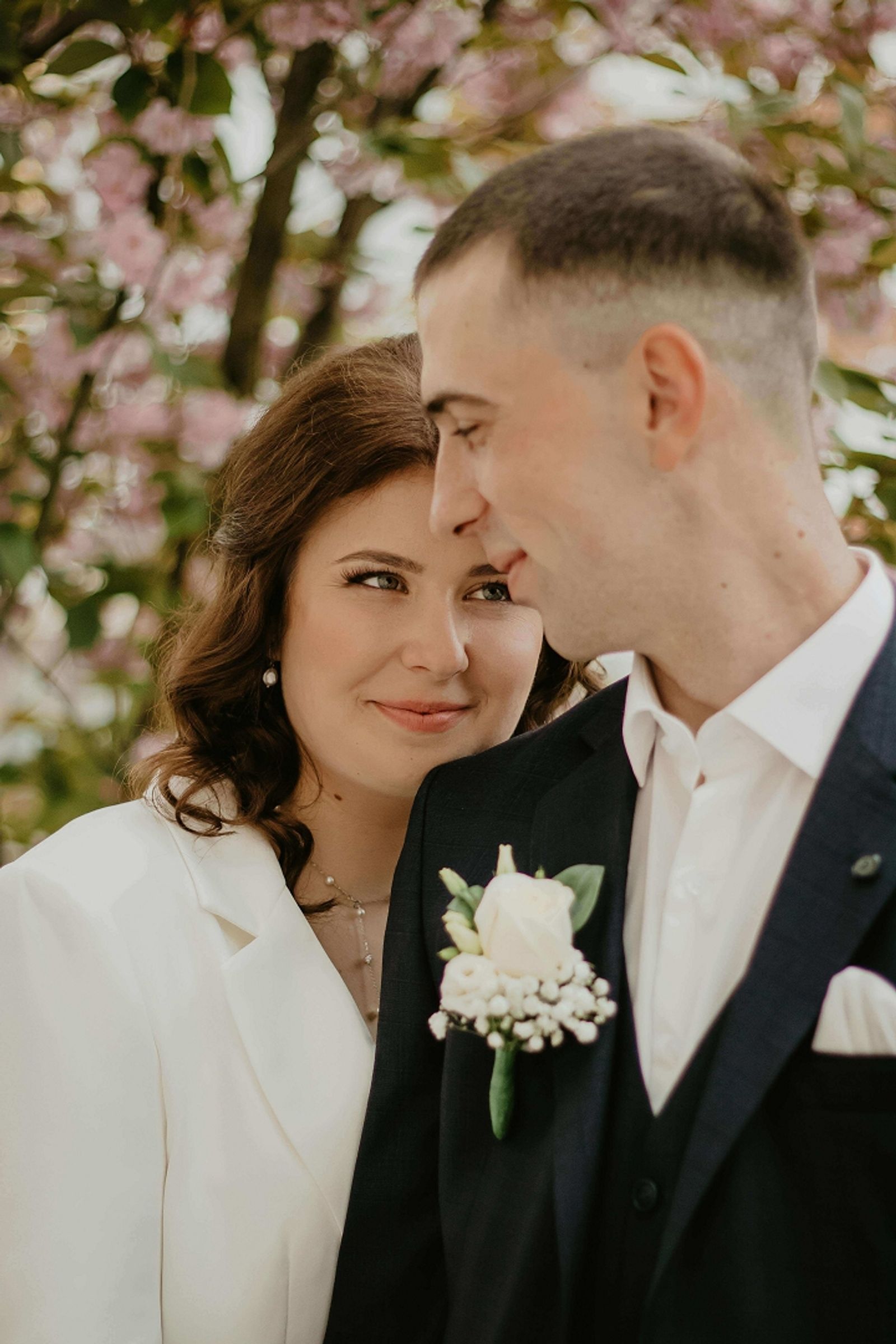 Close portrait of a couple in formal clothing touching foreheads.