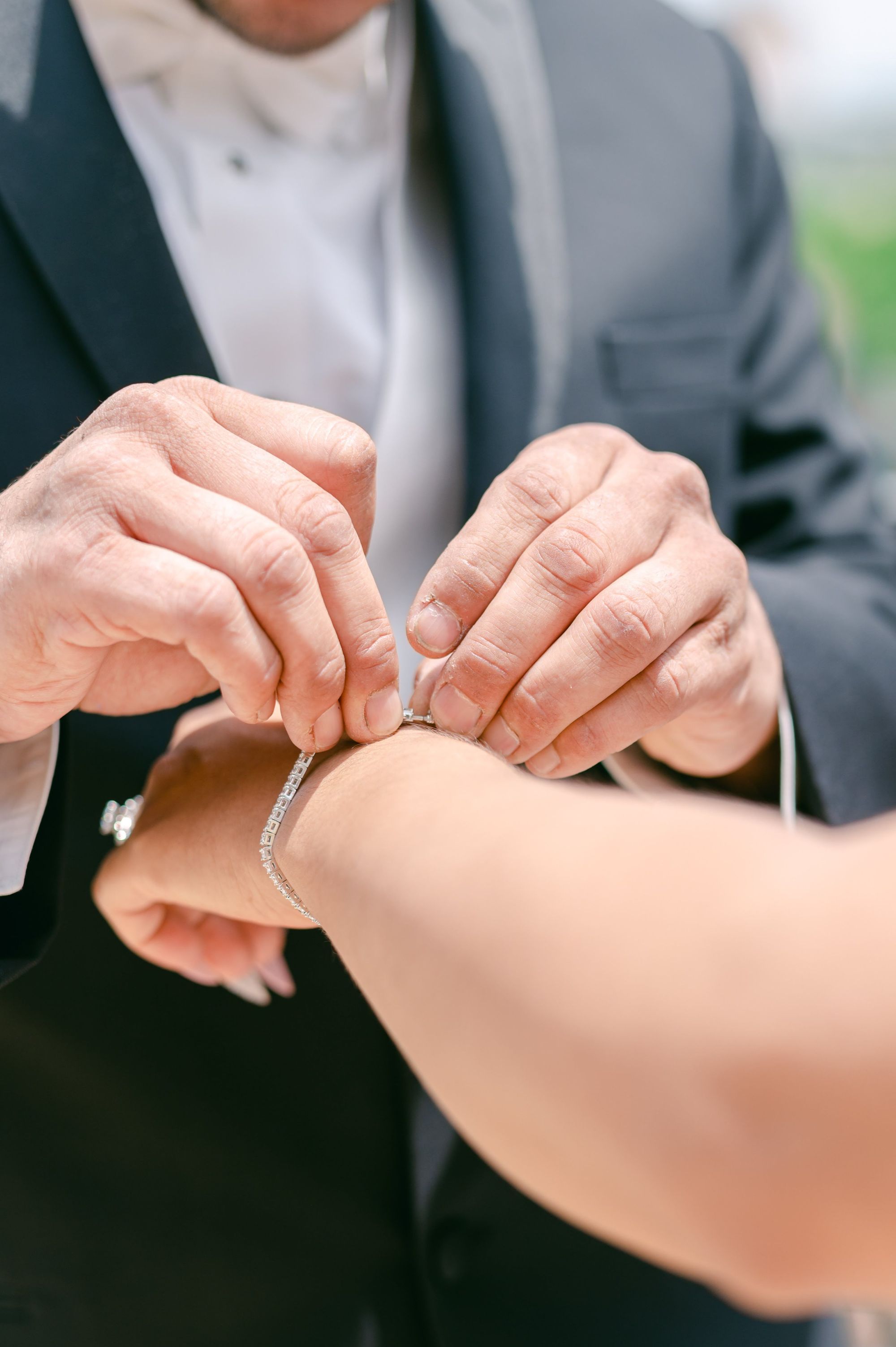 Wrist Jewelry Close crop of hands fastening jewelry around another person's wrist.