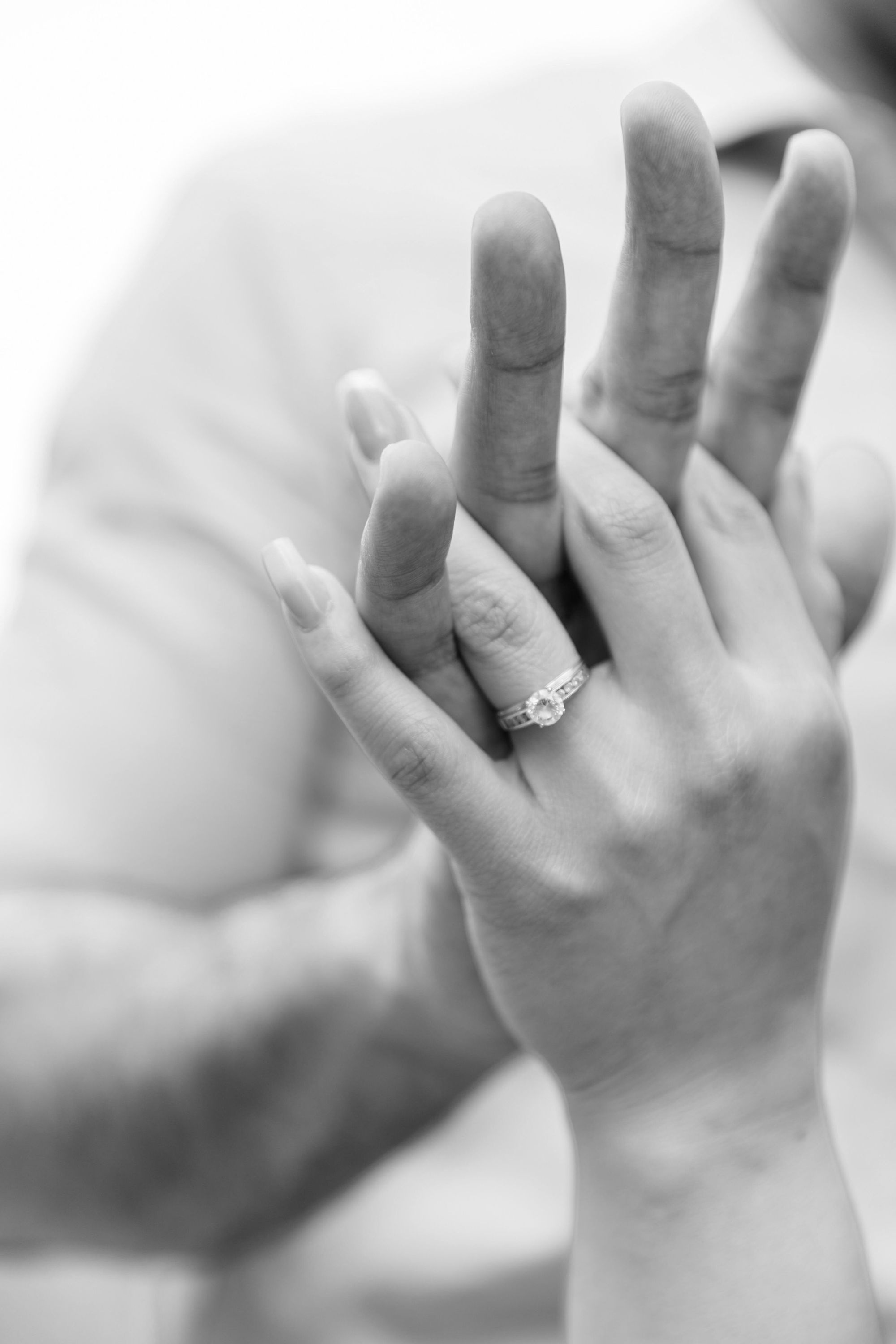 Hands And Ring Black-and-white close-up of two hands pressed together, one wearing a stone ring.
